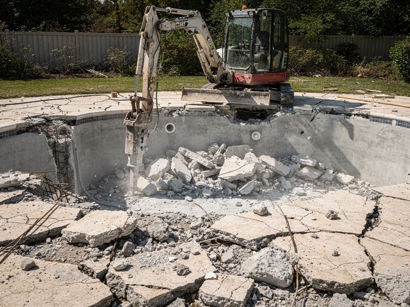 Backyard swimming pool being demolished and filled